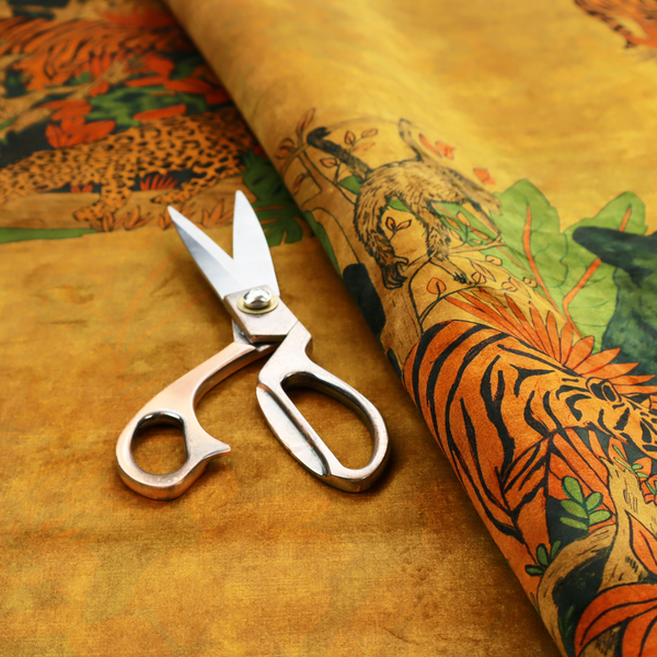 Mustard yellow fabric featuring a repeating jungle panel design with green panthers, tigers, leopards, monkeys, toucans, and lush tropical foliage.