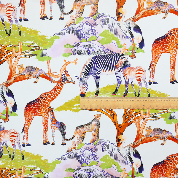 Fabric pattern featuring a vibrant African savanna landscape with giraffes, zebras, cheetahs, and birds among acacia trees and rocky terrain.