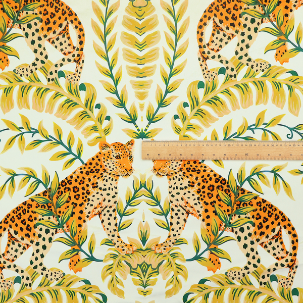 Fabric pattern featuring a symmetrical design of spotted leopards surrounded by golden and green tropical foliage and palm leaves.