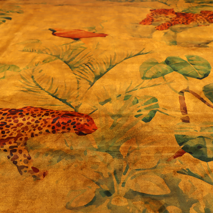 Fabric pattern featuring a warm orange and gold background with jungle wildlife, including leopards, tropical birds, large green leaves, and rocky terrain.