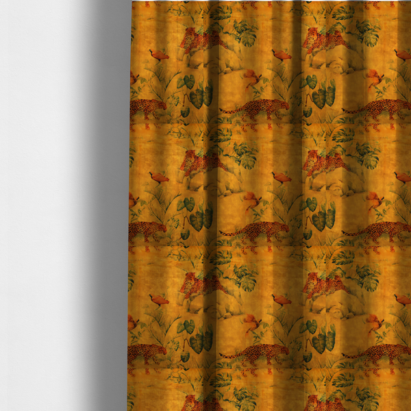 The fabric used to create these made-to-measure curtains is a warm orange and gold background with jungle wildlife, including leopards, tropical birds, large green leaves, and rocky terrain.