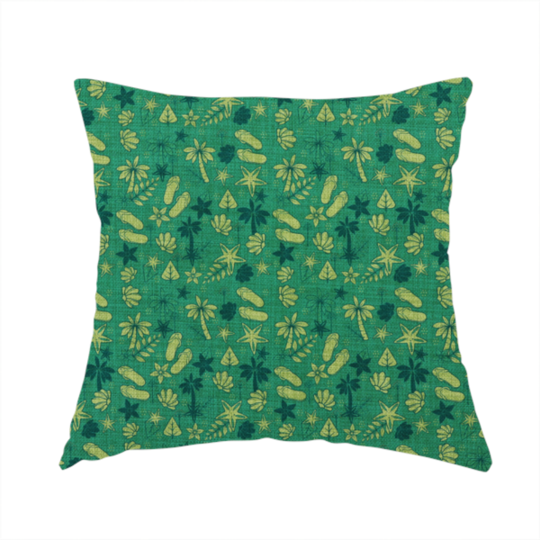 The fabric used to create this handmade cushion is a repeating tropical-themed pattern on textured teal fabric featuring yellow-green flip-flops, seashells, starfish, and tiny palm trees.