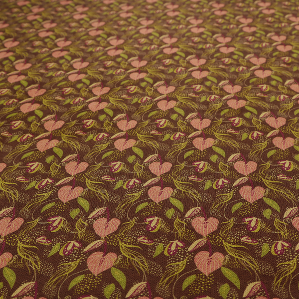 A brown upholstery fabric featuring a repeating pattern of pink heart-shaped leaves, green foliage, and delicate botanical details.
