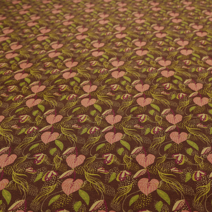 A brown upholstery fabric featuring a repeating pattern of pink heart-shaped leaves, green foliage, and delicate botanical details.
