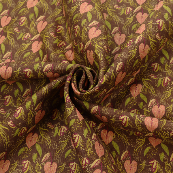 A brown upholstery fabric featuring a repeating pattern of pink heart-shaped leaves, green foliage, and delicate botanical details.