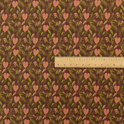 A brown upholstery fabric featuring a repeating pattern of pink heart-shaped leaves, green foliage, and delicate botanical details.