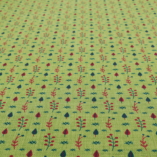 A green upholstery fabric featuring a ditsy folk-art pattern of small red berries, sprigs, and dark blue leaves.
