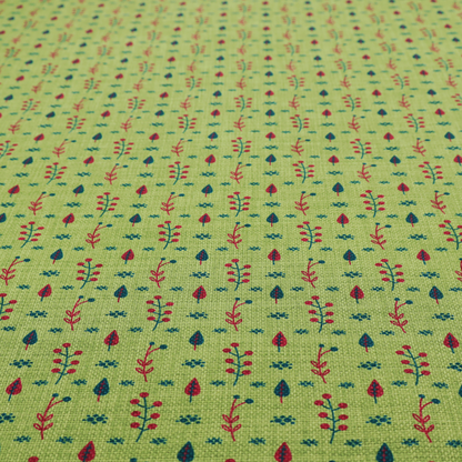 A green upholstery fabric featuring a ditsy folk-art pattern of small red berries, sprigs, and dark blue leaves.