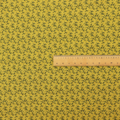 Mustard yellow fabric featuring a dense, repeating pattern of small dark green or black trailing vines with tiny leaves and a subtle woven texture.