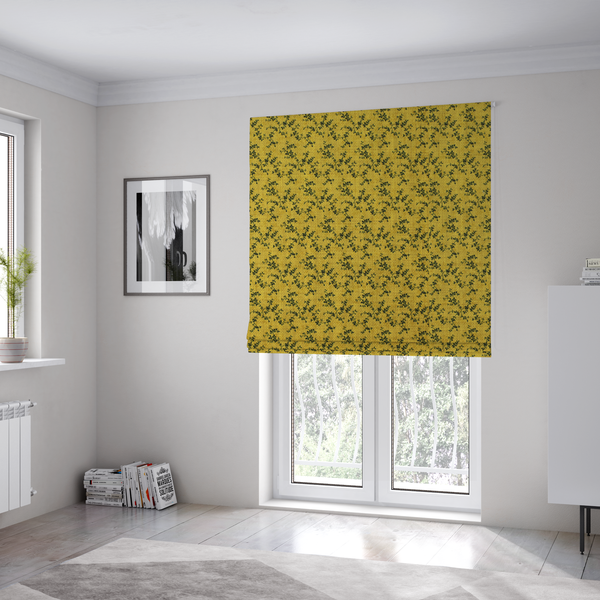 The fabric used to create these Roman blinds is a mustard yellow fabric featuring a dense, repeating pattern of small dark green or black trailing vines with tiny leaves and a subtle woven texture.