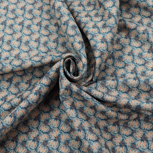 A dark blue and slate textured fabric featuring a dense, repeating mosaic pattern of small tropical leaves in shades of cream and rust orange.