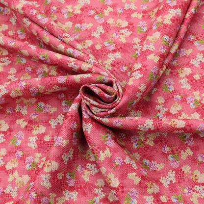 A vibrant raspberry pink fabric featuring a dense, repeating pattern of small white, purple, and green floral clusters over a subtle checked texture.