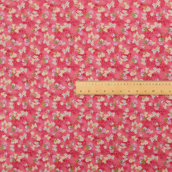 A vibrant raspberry pink fabric featuring a dense, repeating pattern of small white, purple, and green floral clusters over a subtle checked texture.