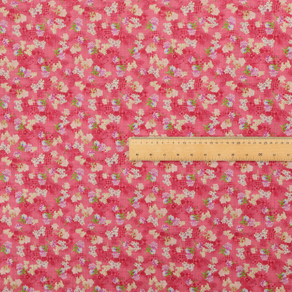 A vibrant raspberry pink fabric featuring a dense, repeating pattern of small white, purple, and green floral clusters over a subtle checked texture.