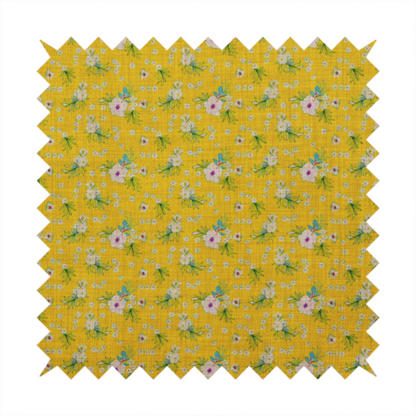 Textured mustard yellow fabric featuring a repeating micro floral pattern of small white and pink blossoms with green leaves and blue accents.