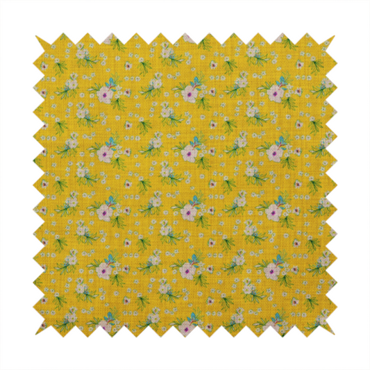 Textured mustard yellow fabric featuring a repeating micro floral pattern of small white and pink blossoms with green leaves and blue accents.