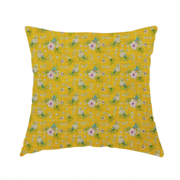 The fabric used to create this handmade cushion is a textured mustard yellow fabric featuring a repeating micro floral pattern of small white and pink blossoms with green leaves and blue accents.