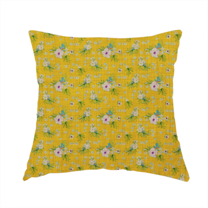 The fabric used to create this handmade cushion is a textured mustard yellow fabric featuring a repeating micro floral pattern of small white and pink blossoms with green leaves and blue accents.