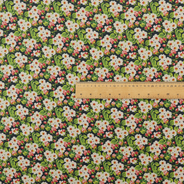 A dense vintage-style micro-floral print fabric featuring tiny white blossoms, pink buds, and green leaves set against a dark background.