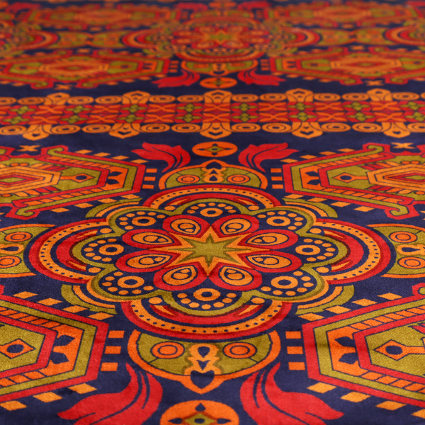 A deep purple textile adorned with intricate, ornate patterns including large mandala medallions, geometric motifs, and a central horizontal decorative stripe in shades of red, orange, and olive green.