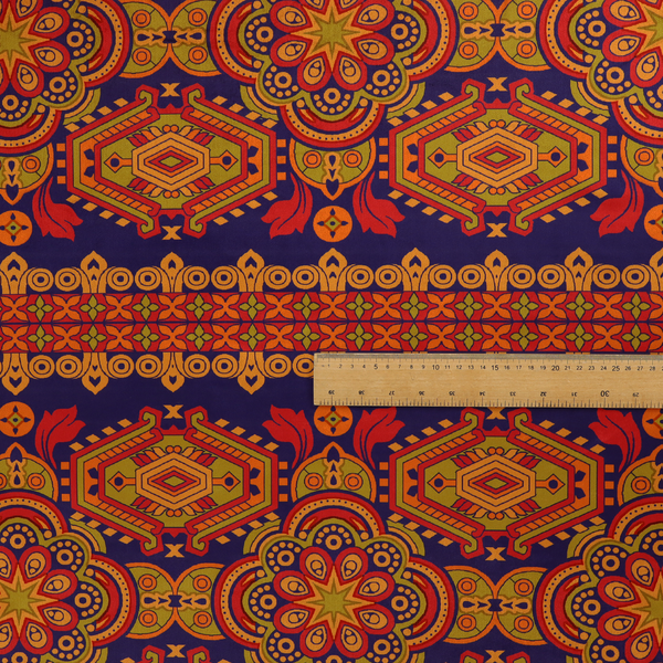 A deep purple textile adorned with intricate, ornate patterns including large mandala medallions, geometric motifs, and a central horizontal decorative stripe in shades of red, orange, and olive green.