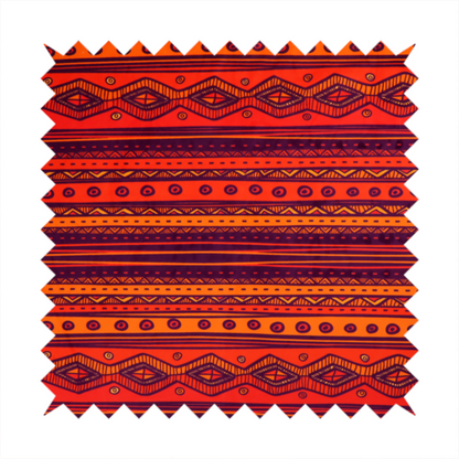 A vibrant orange and red fabric featuring a repeating tribal geometric and striped pattern.