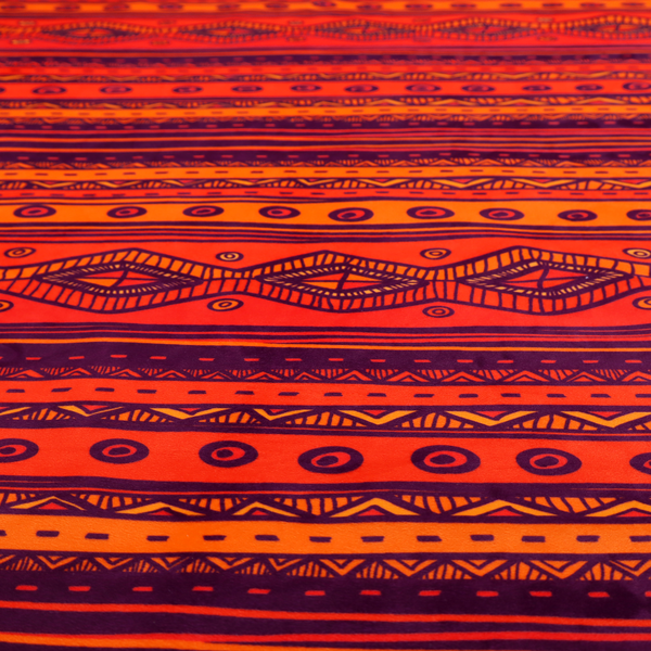 A vibrant orange and red fabric featuring a repeating tribal geometric and striped pattern.