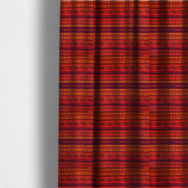 The fabric used to create these made-to-measure curtains is a vibrant orange and red fabric featuring a repeating tribal geometric and striped pattern.