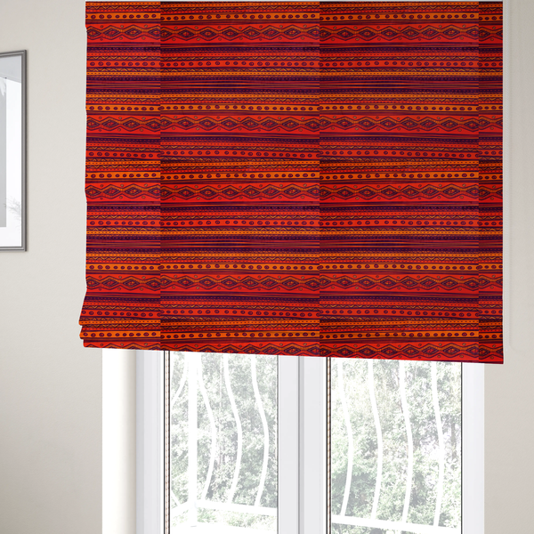 The fabric used to create these Roman blinds is a vibrant orange and red fabric featuring a repeating tribal geometric and striped pattern.