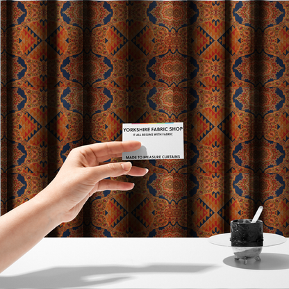 The fabric used to create these made-to-measure curtains is a large, diamond-shaped geometric centrepiece filled with fine diagonal lines and stair-step tribal or Aztec-inspired patterns in orange and dark blue.