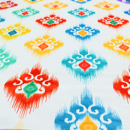 The image features a colourful, patterned textile with an ikat-style design and repeating diamond motifs.