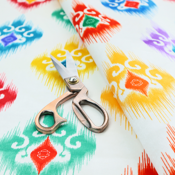 The image features a colourful, patterned textile with an ikat-style design and repeating diamond motifs.