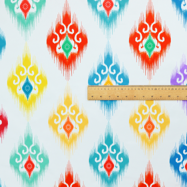The image features a colourful, patterned textile with an ikat-style design and repeating diamond motifs.