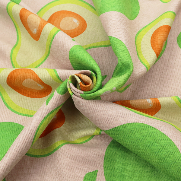 A repeating pattern fabric featuring whimsical illustrations of whole green avocados with small leaves and sliced avocado halves showing bright orange pits, all scattered across a light pink background.