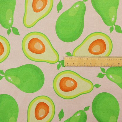 A repeating pattern fabric featuring whimsical illustrations of whole green avocados with small leaves and sliced avocado halves showing bright orange pits, all scattered across a light pink background.