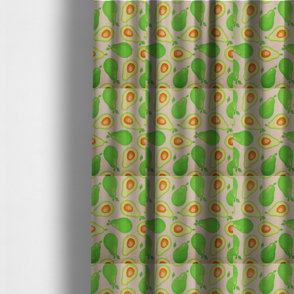 The fabric used to create these made-to-measure curtains is a repeating pattern fabric featuring whimsical illustrations of whole green avocados with small leaves and sliced avocado halves showing bright orange pits, all scattered across a light pink background.