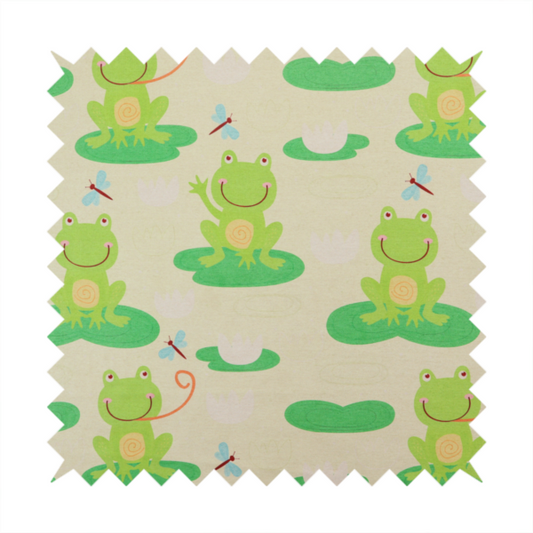 A repeating pattern fabric featuring cute cartoon green frogs sitting on bright green lily pads, interspersed with blue and red dragonflies and white water lilies on a light cream background.