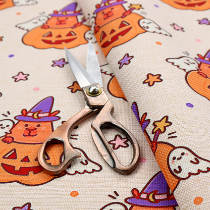 A seamless, repeating Halloween-themed pattern featuring cute capybaras dressed as witches with purple hats and holding magic star wands, peeking out of carved jack-o'-lantern pumpkins, accompanied by friendly little ghosts, orange and purple stars, and polka dots on a light fabric-textured background.