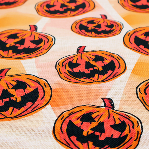 A seamless, repeating Halloween-themed pattern featuring vibrant orange carved jack-o'-lantern pumpkins with bold, black spooky expressions and lined details set against an abstract geometric orange and cream background.