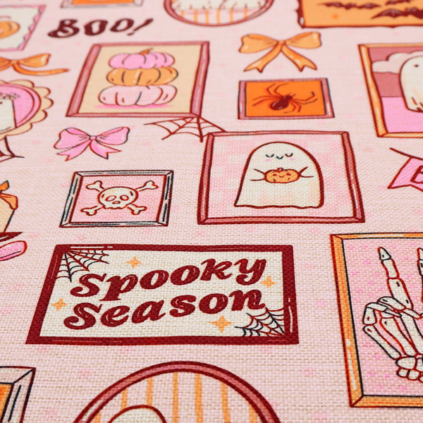 A seamless, repeating Halloween-themed pattern featuring a pink gallery wall filled with framed art, including cute ghosts, stacked pumpkins, a witch hat, a "Spooky Season" sign, bats, mushrooms, bows, spiderwebs, candles, and a skeletal peace sign hand on a light pink textured background.