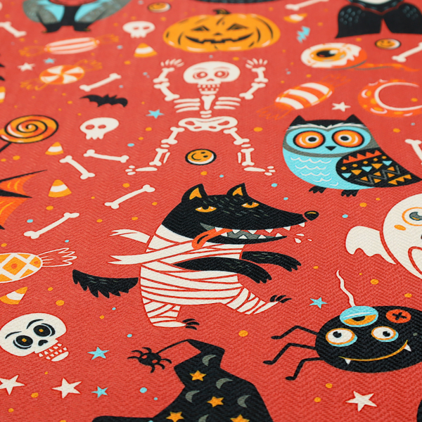 A seamless, repeating Halloween-themed pattern featuring a vibrant red-orange background filled with a dancing skeleton, vampires, a mummified dog, a blue owl, black cats, a flying bat, ghosts, a jack-o'-lantern, candy, skulls, trees, and whimsical monsters.