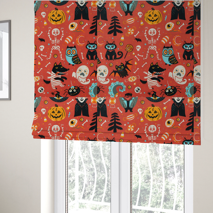 The fabric used to create these Roman blinds is a seamless, repeating Halloween-themed pattern featuring a vibrant red-orange background filled with a dancing skeleton, vampires, a mummified dog, a blue owl, black cats, a flying bat, ghosts, a jack-o'-lantern, candy, skulls, trees, and whimsical monsters.