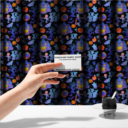 The fabric used to create these made-to-measure curtains is a seamless, repeating Halloween-themed pattern featuring a black background filled with glowing blue haunted houses, flying ghosts, orange jack-o'-lanterns, gnarled trees, bats, a crescent moon, and fleeing children.