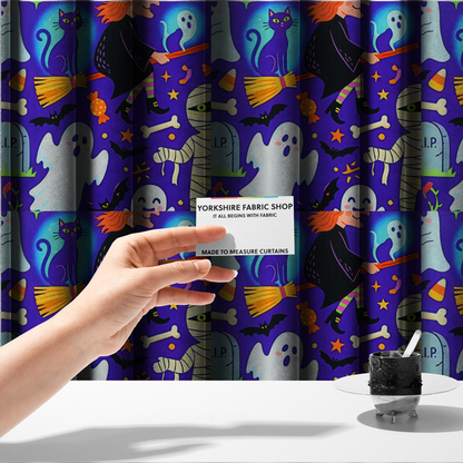 The fabric used to create these made-to-measure curtains is a seamless, repeating Halloween-themed pattern featuring a vibrant purple background filled with a witch riding a broomstick with a black cat, a mummified figure, ghosts, bats, a tombstone, bones, candy, and stars.