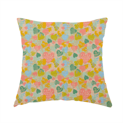 The fabric used to create this handmade cushion is a colourful repeating pattern of overlapping hearts in shades of pink, teal, yellow, and blue, set against a textured background.