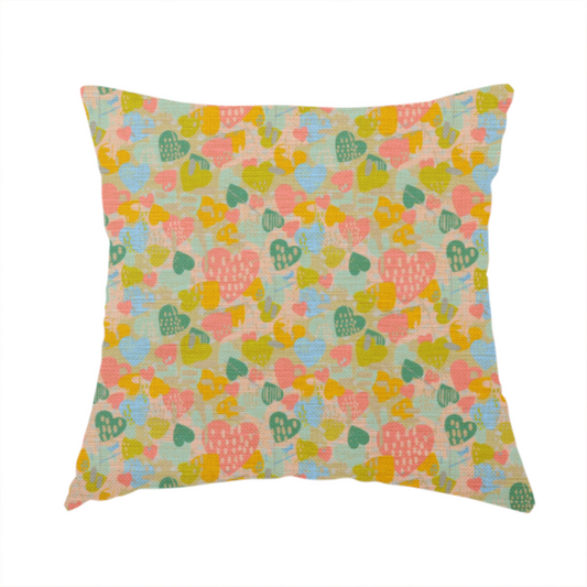 The fabric used to create this handmade cushion is a colourful repeating pattern of overlapping hearts in shades of pink, teal, yellow, and blue, set against a textured background.