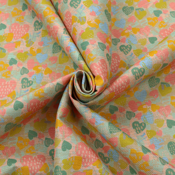 A colourful repeating pattern of overlapping hearts in shades of pink, teal, yellow, and blue, set against a textured background.