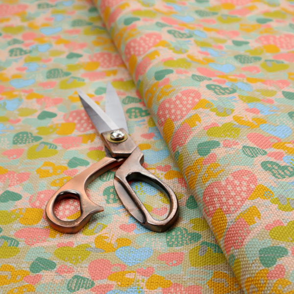 A colourful repeating pattern of overlapping hearts in shades of pink, teal, yellow, and blue, set against a textured background.