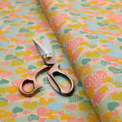 A colourful repeating pattern of overlapping hearts in shades of pink, teal, yellow, and blue, set against a textured background.