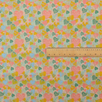 A colourful repeating pattern of overlapping hearts in shades of pink, teal, yellow, and blue, set against a textured background.